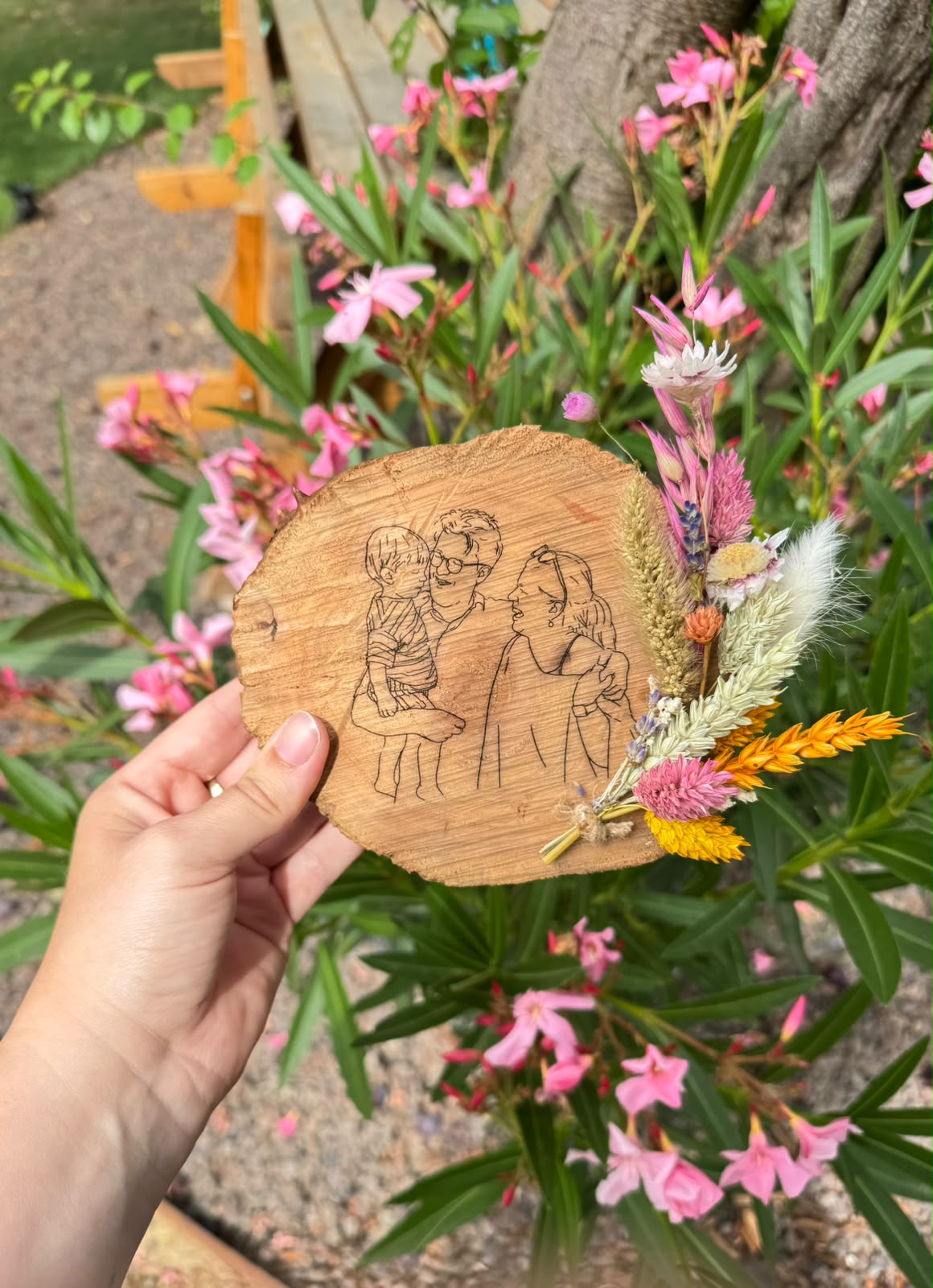 houten schijf met lijntekening en droogbloemen